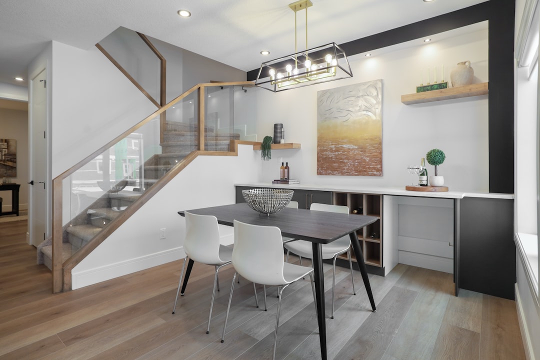 Sala da pranzo con tavolo in rovere, illuminazione a sospensione e parete in pietra